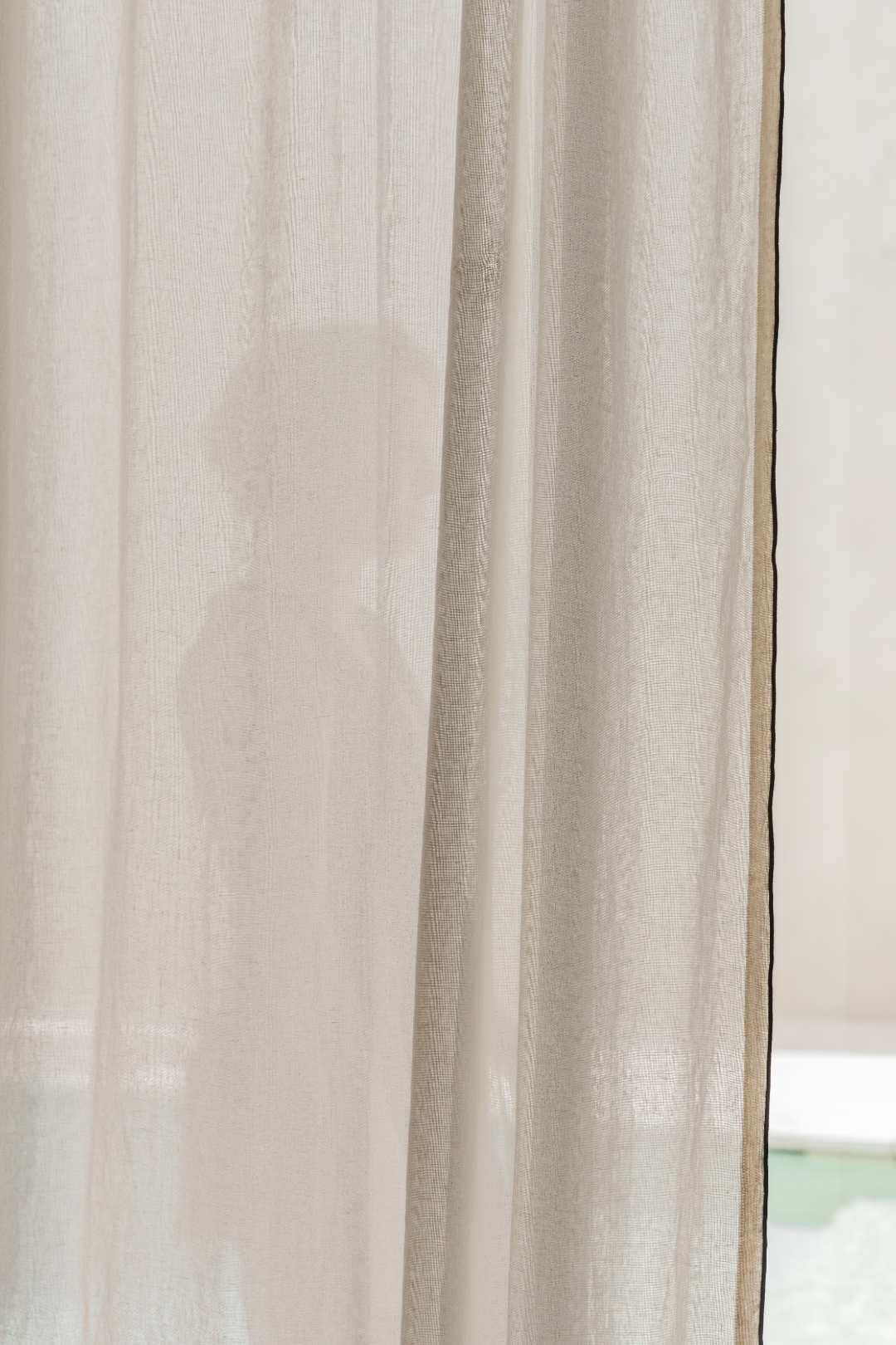 Sheer beige curtain with a blurred background