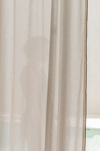Sheer beige curtain with a blurred background